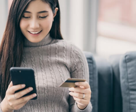 A woman looking at her phone while shopping online